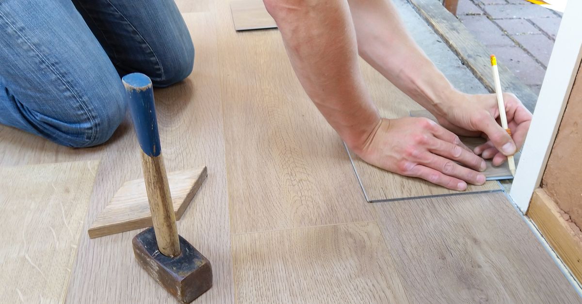 Close-up of flooring installation showing precision tool work and material preparation